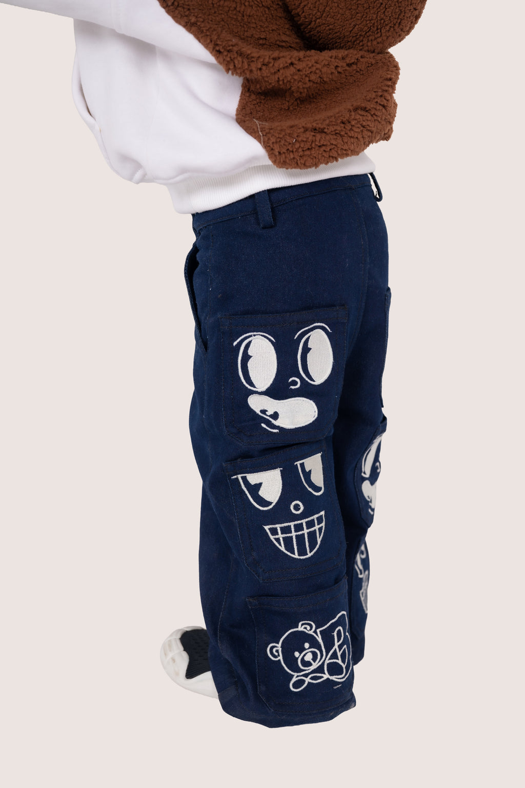 Luxury navy blue children's pants with embroidered playful faces and teddy bear details