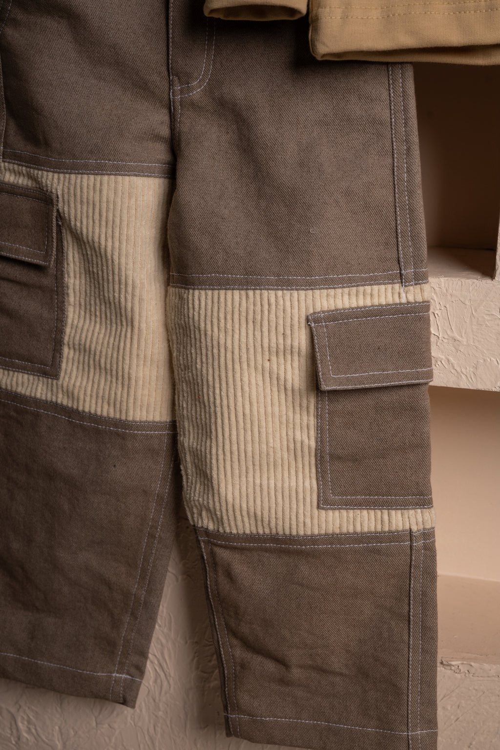 Close-up of luxury brown and beige patchwork pants with textured corduroy and contrast stitching